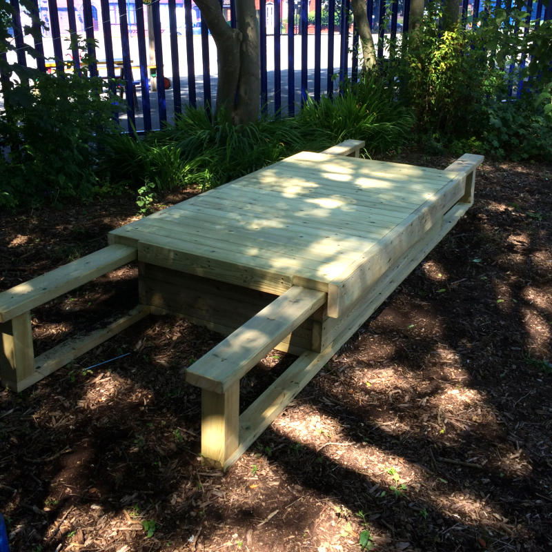 Sliding lid sandpit with the lid closed and sand covered