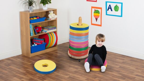 Child sat on a donut cushion in classroom in front of a Donut Multi Seat Trolley with 12 Cushions