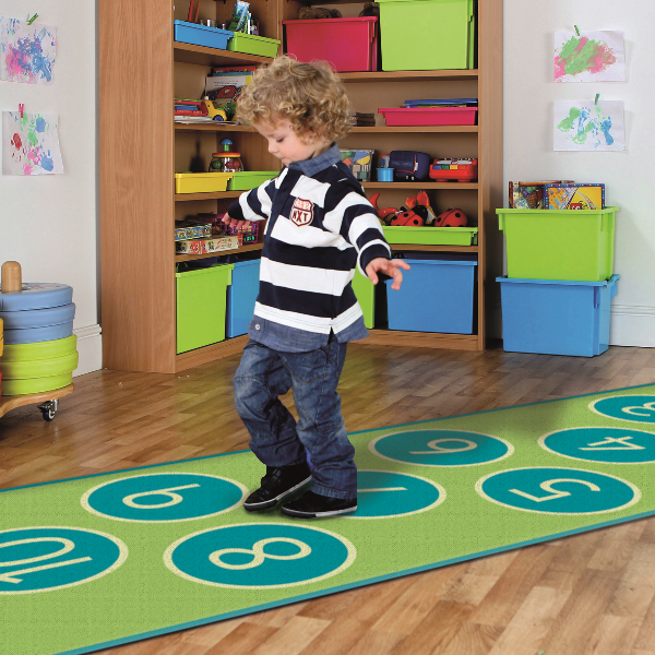 Child playing hopscotch on long narrow carpet in shades of green