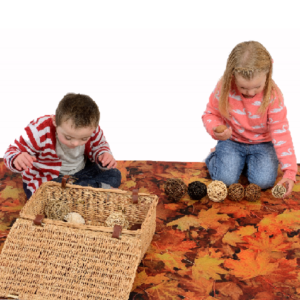 Children sat on a Nature Play Mat Leaves themed design