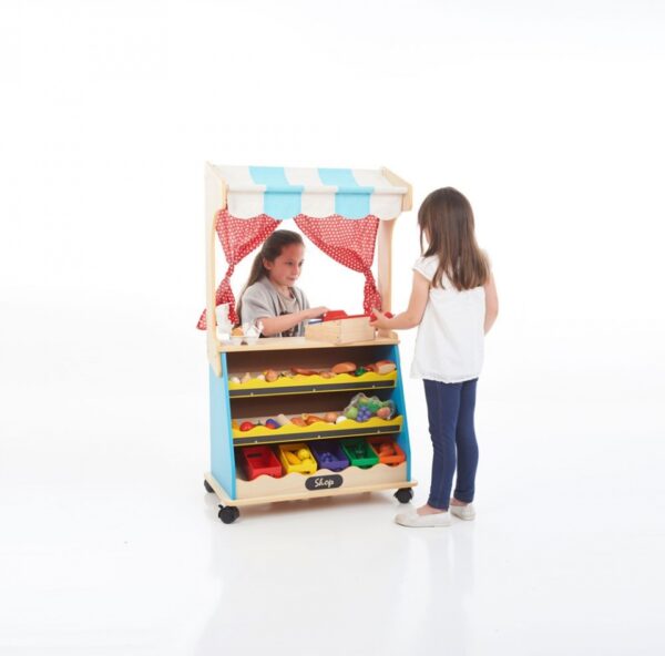 Children playing with wooden play shop with curtains and canopy. Other side of unit is a play theatre
