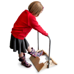 Primary school child holding handle and using welly boot remover to take off wellies