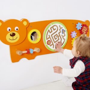 Child playing with orange wall mounted bear game containing various puzzles for children