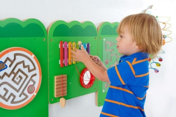Child Playing with Xylophone that forms part of a wall mounted crocodile wall game