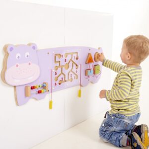 Little boy playing with Hippo Wall game. Pink Hippo with puzzles