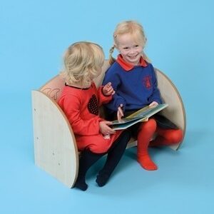 Two children sat together readying on a Nursery Mini Bench Seat with maple finish