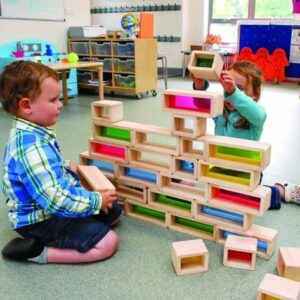 Children playing with rainbow bricks made from rubber wood exterior with a coloured acrylic interior to create coloured inserts