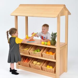 Children playing shop with the Room Scenes Shop with Canopy. With six angled baskets on the front for the shop keeper to display with items.