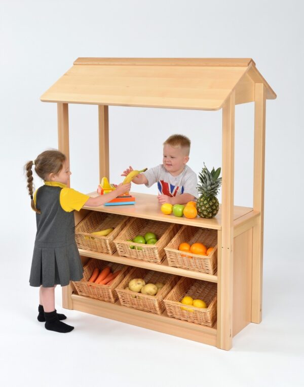 Children playing shop with the Room Scenes Shop with Canopy. With six angled baskets on the front for the shop keeper to display with items.