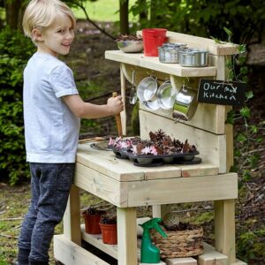 Boy playing at small wooden mud kitchen