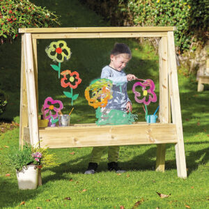 Child standing at Outdoor Large Easel with mark making clear surface drawing images of flowers