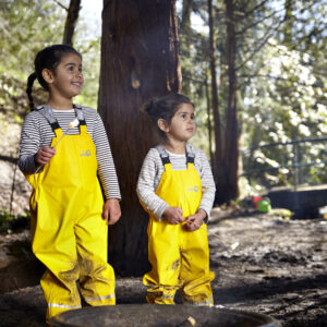 Children wearing yellow Forest Ranger dungarees playing outside