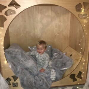 child sat in a wooden sensory den